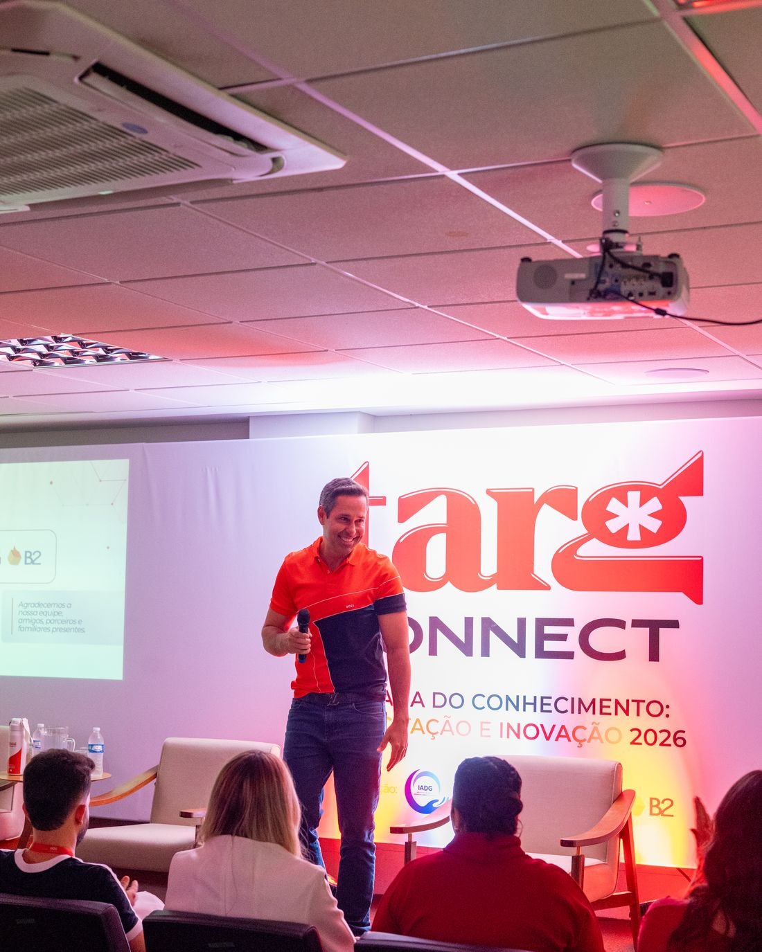 Palestra durante o Targ Connect, com plateia e telão de fundo